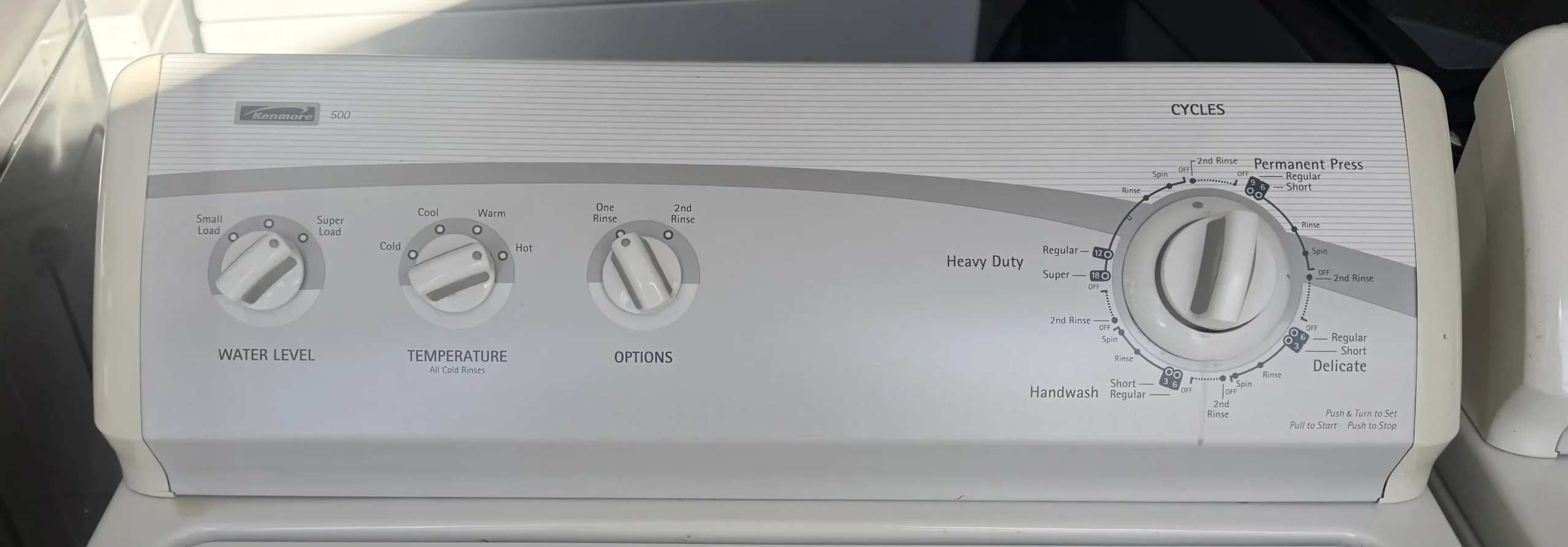 Kenmore washer control panel with four cycle dials set to heavy duty