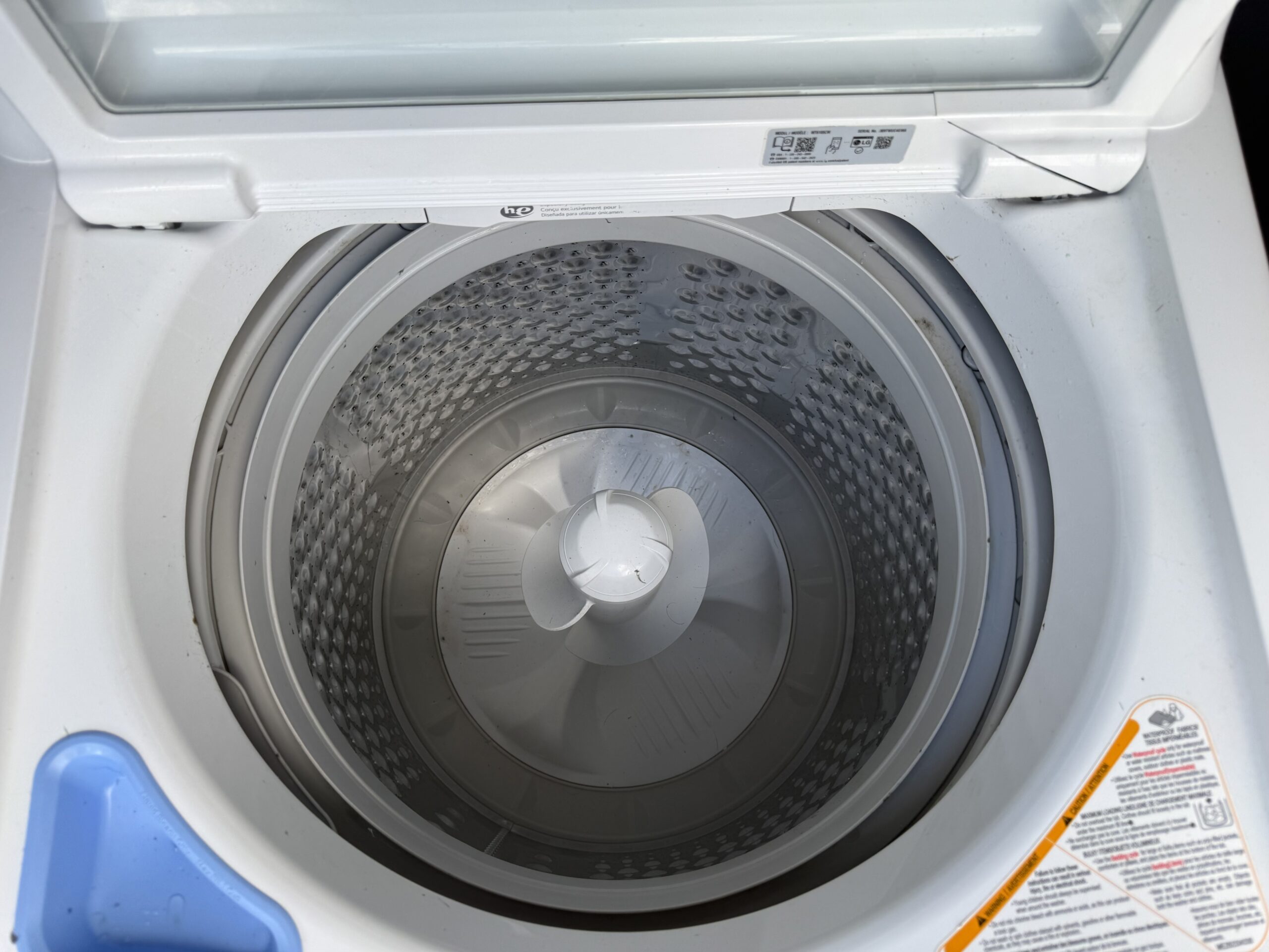 LG washer top-load lid open showing wash basket and agitator