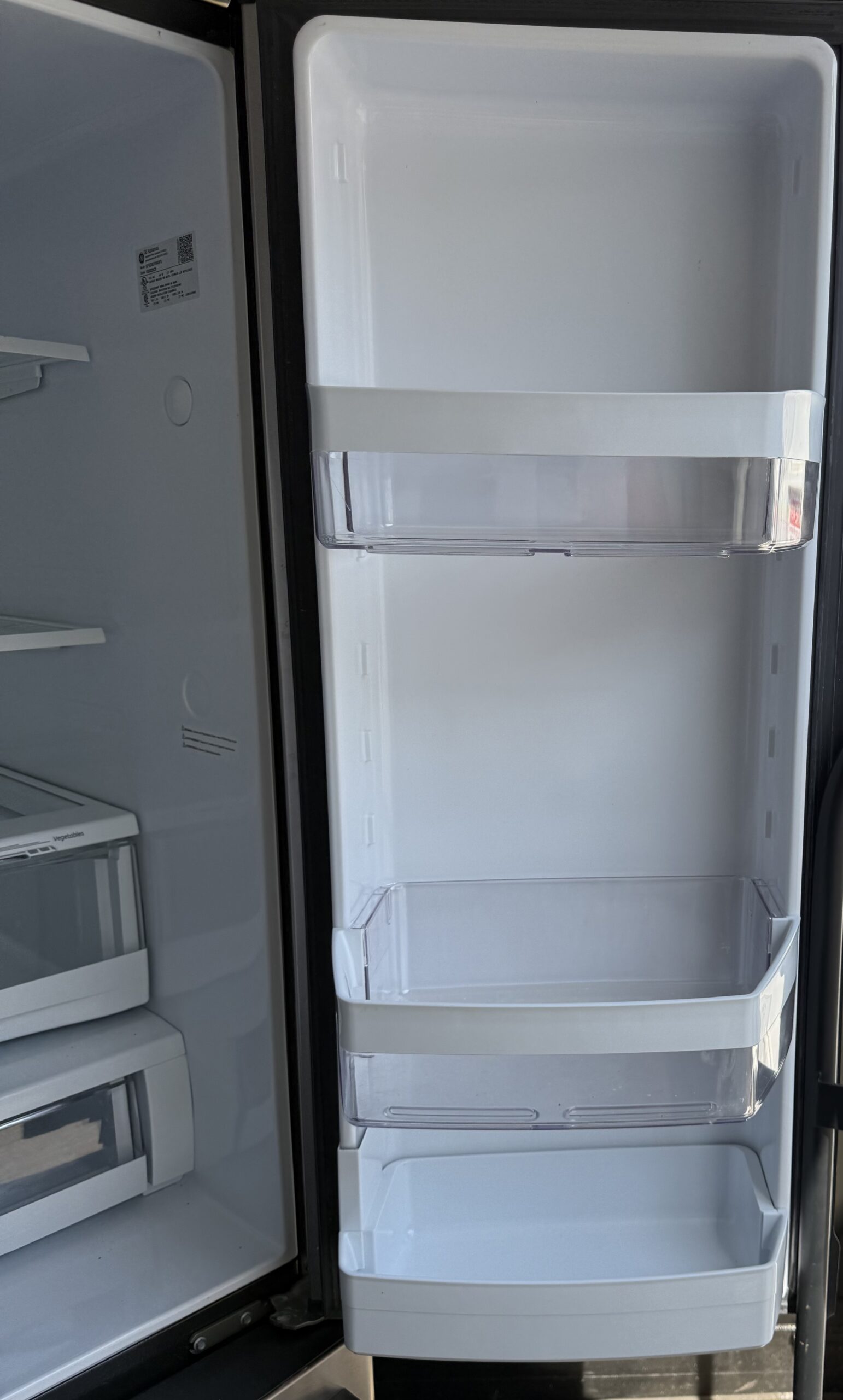 GE refrigerator right door interior with adjustable shelf bins and gallon-size storage