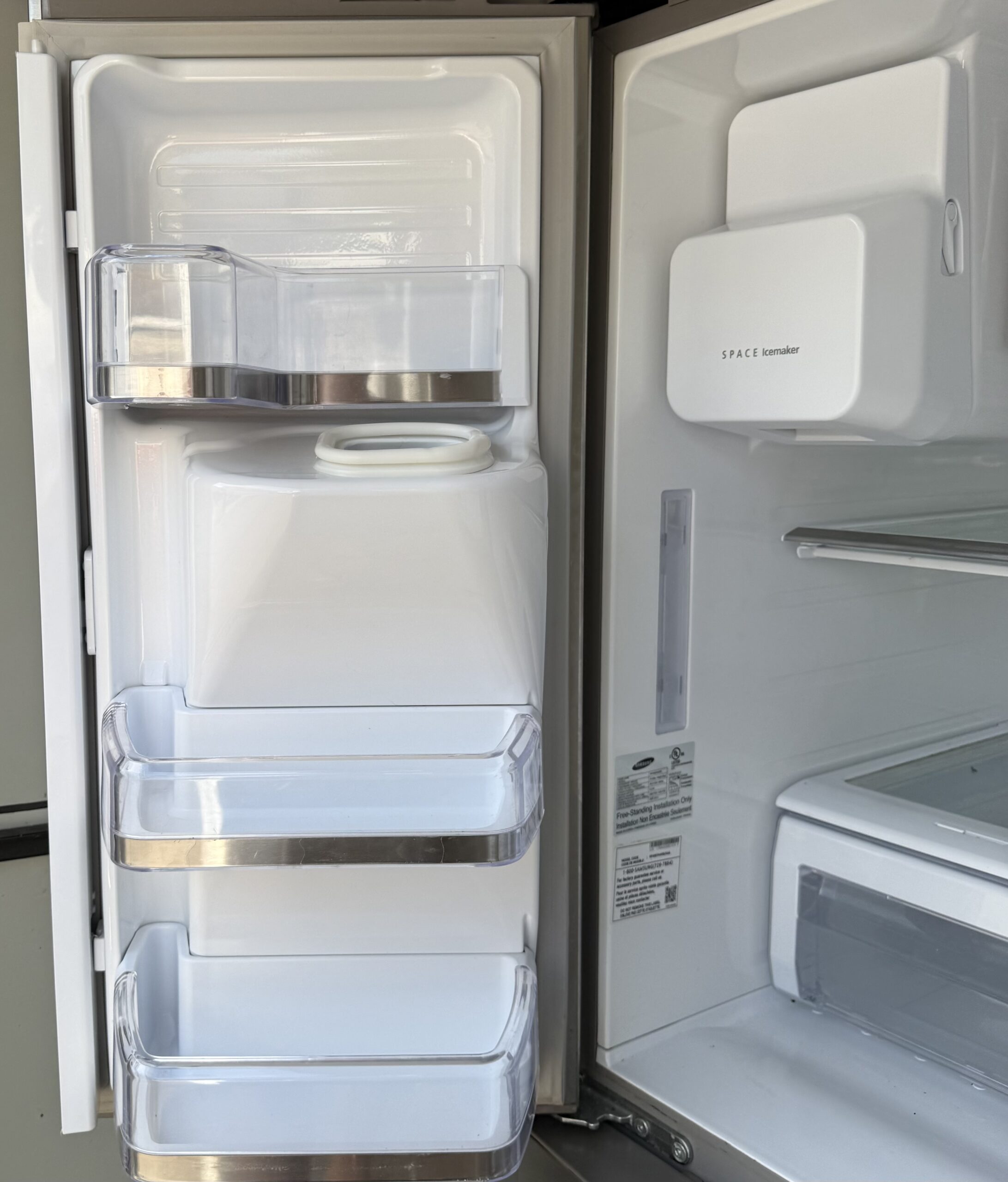 Samsung refrigerator left door interior with water and ice dispenser back panel and adjustable bin storage