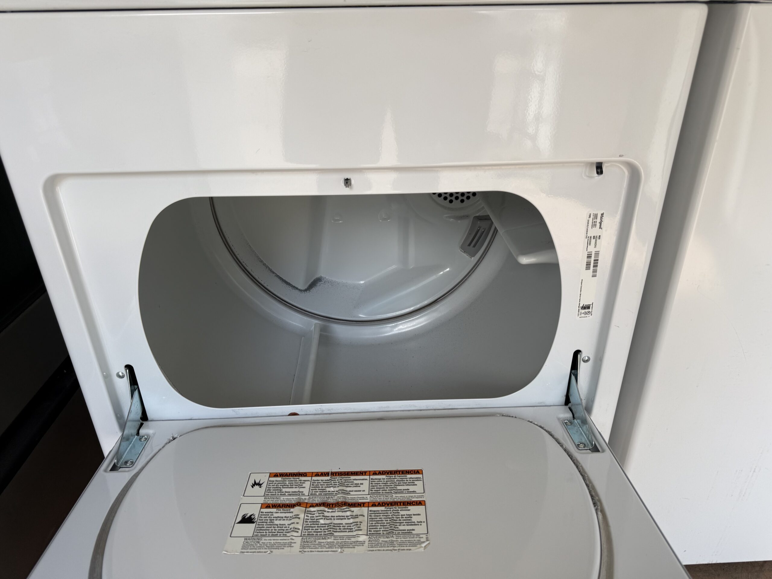 Whirlpool electric dryer drum interior with side-swing door open, white