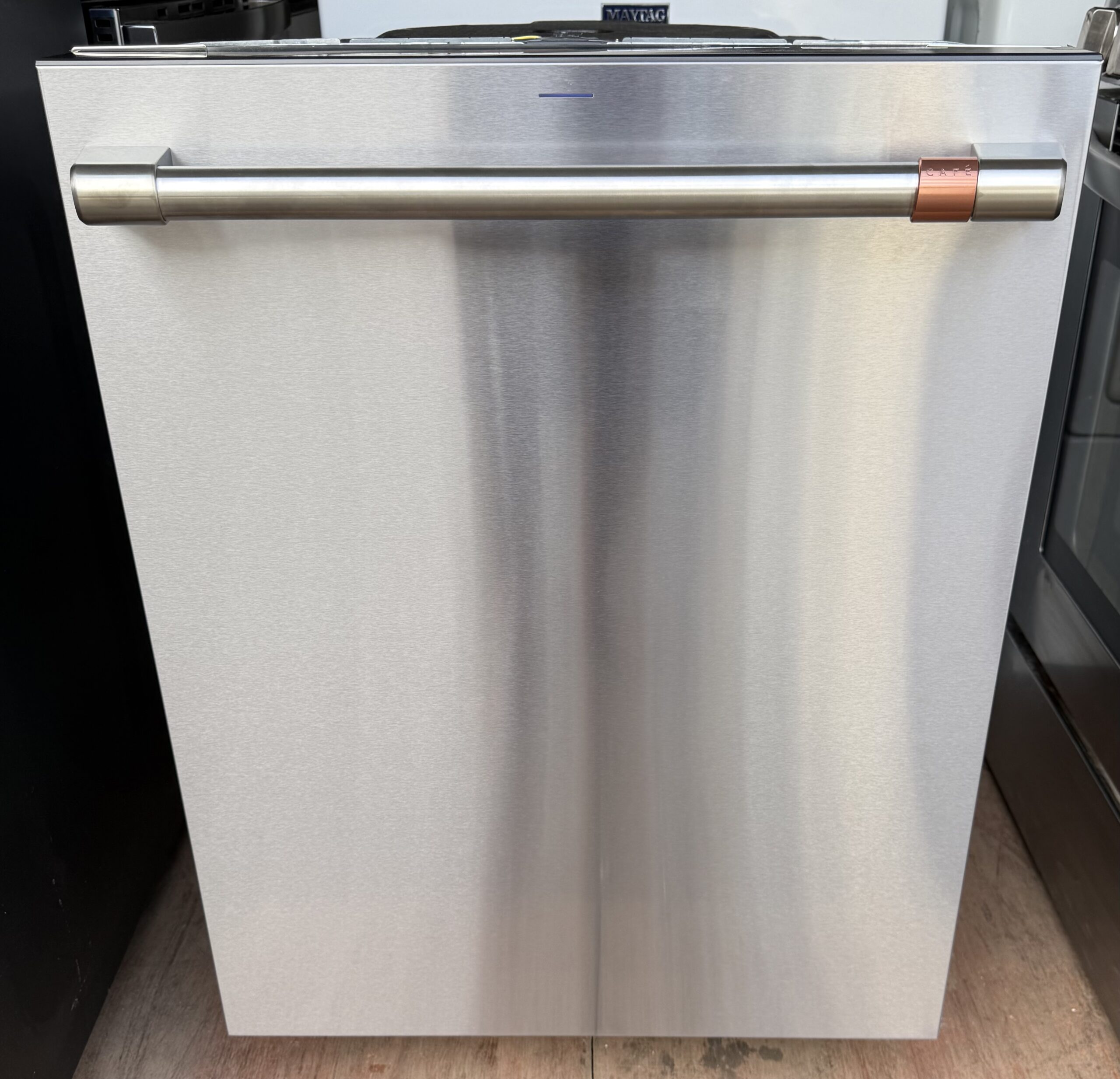 Café stainless steel dishwasher, full front view with brushed stainless bar handle and copper accent