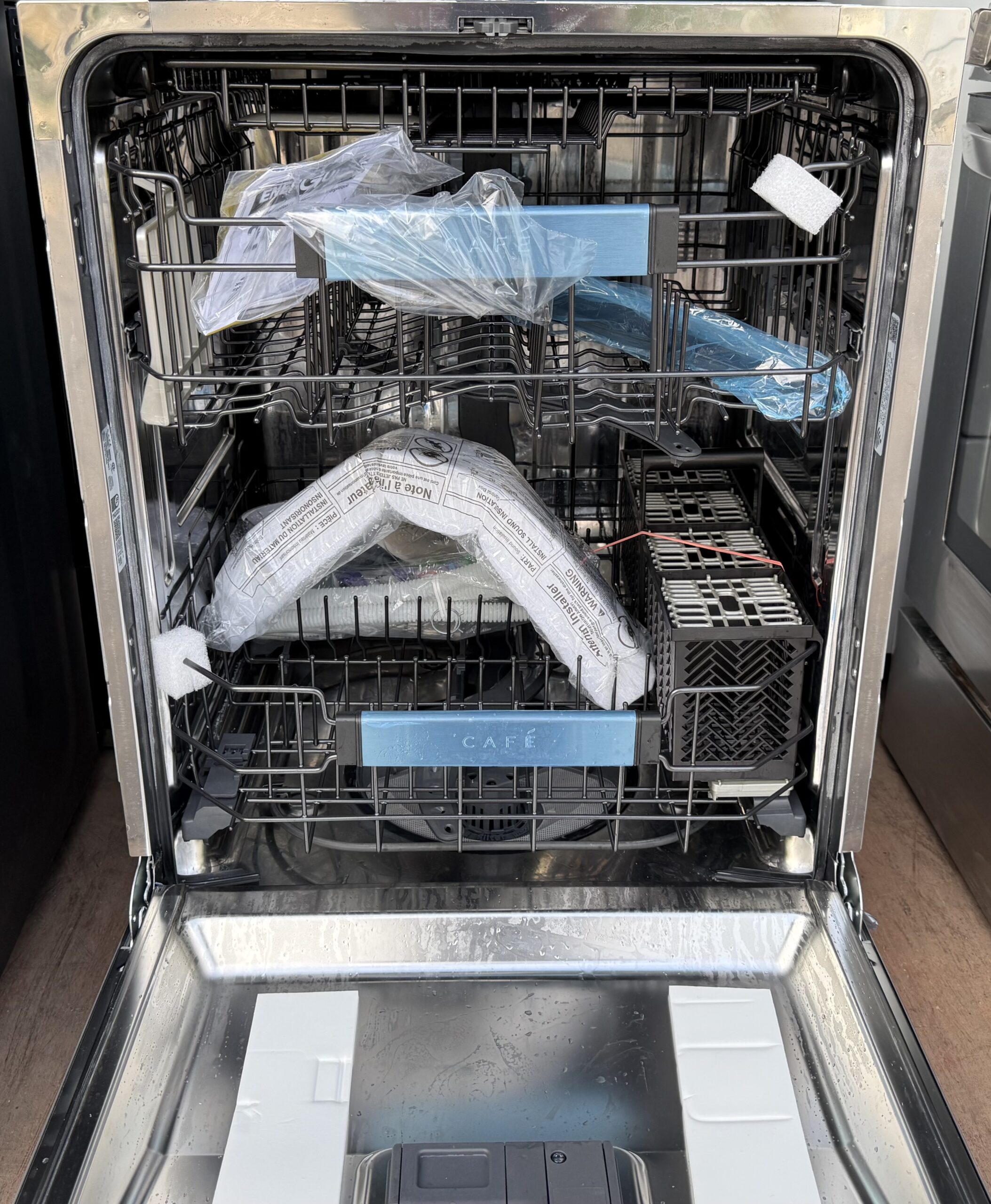 Café dishwasher interior with stainless tub, third rack, and adjustable racks