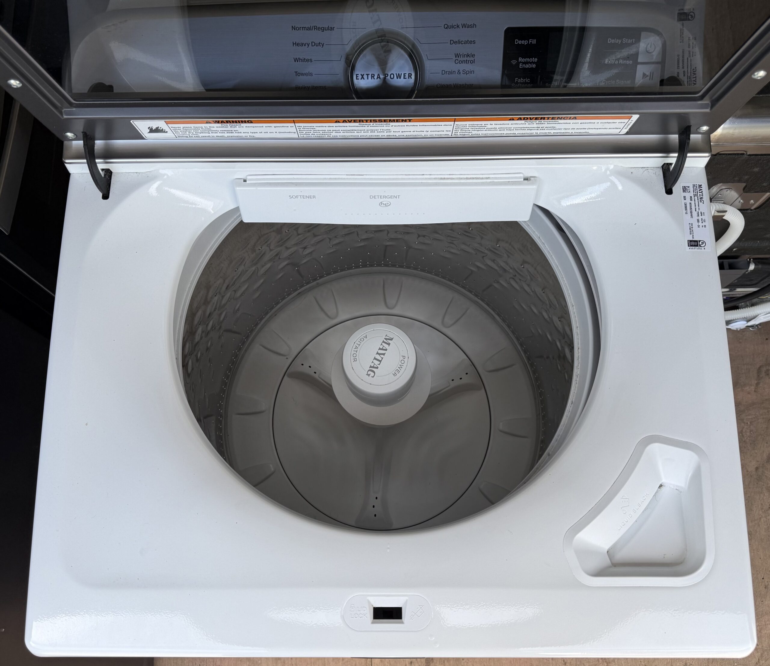 Maytag top-load washer interior with stainless wash basket, pole agitator, and detergent dispenser