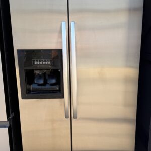 Whirlpool side-by-side refrigerator in stainless steel with ice and water dispenser, front view