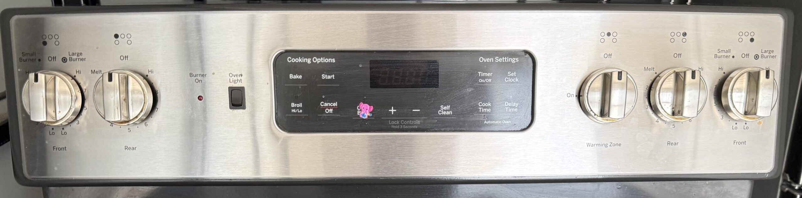 GE electric range stainless control panel with knobs and oven display