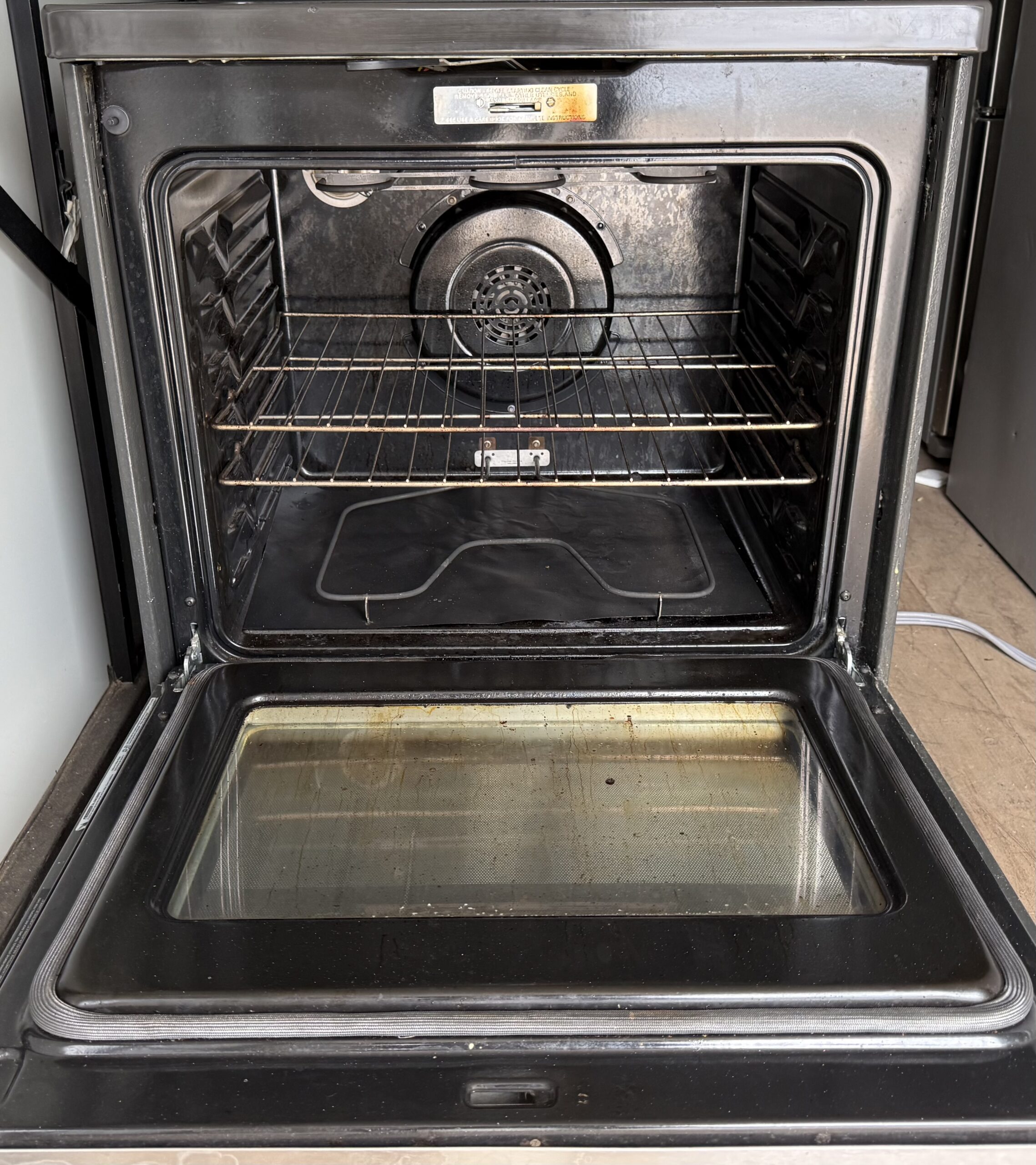 GE electric range oven interior with convection fan and racks
