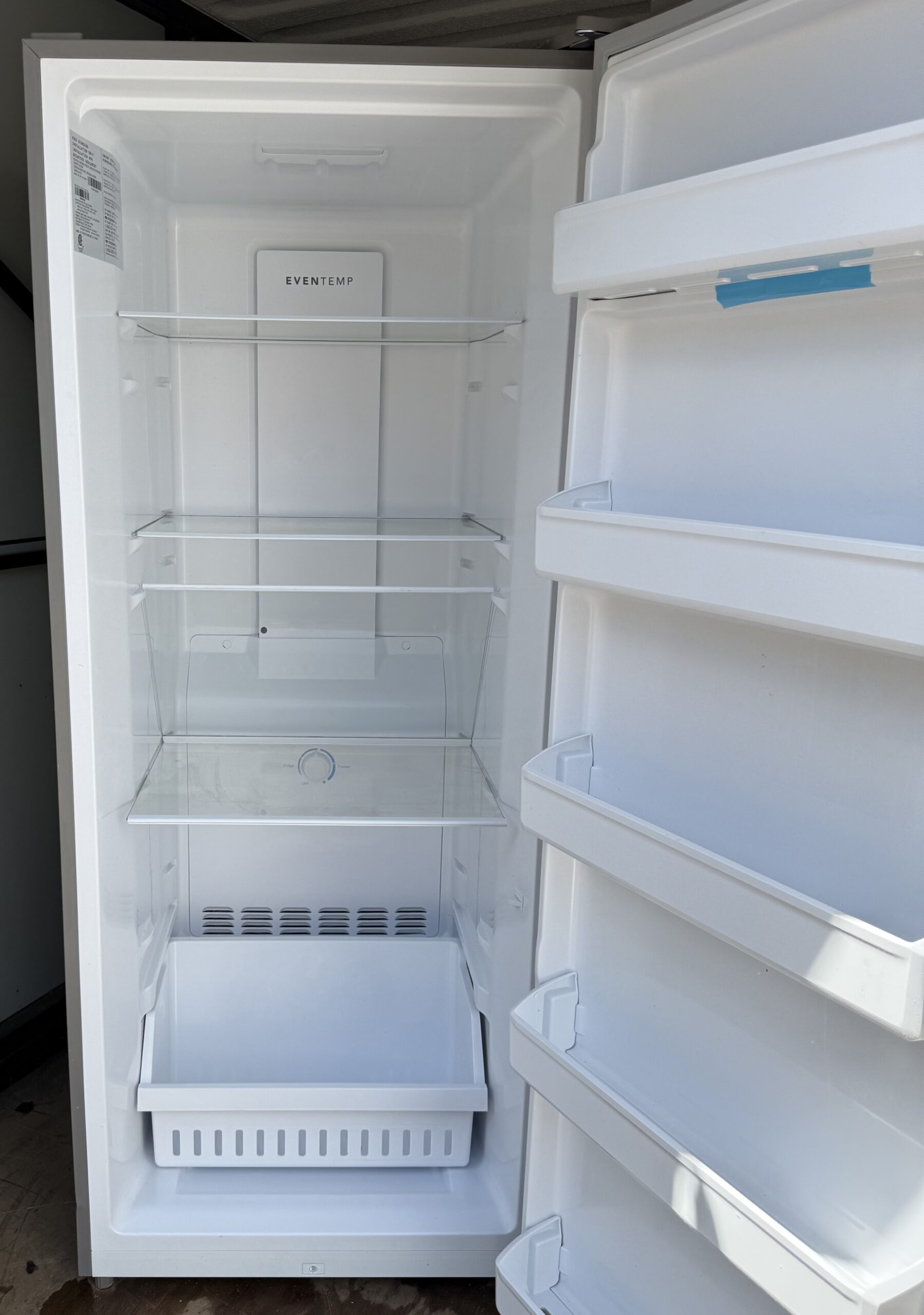 Frigidaire upright freezer interior with glass shelves and door bins