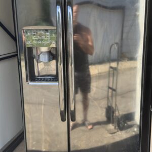 GE side-by-side refrigerator black with ice and water dispenser — front view