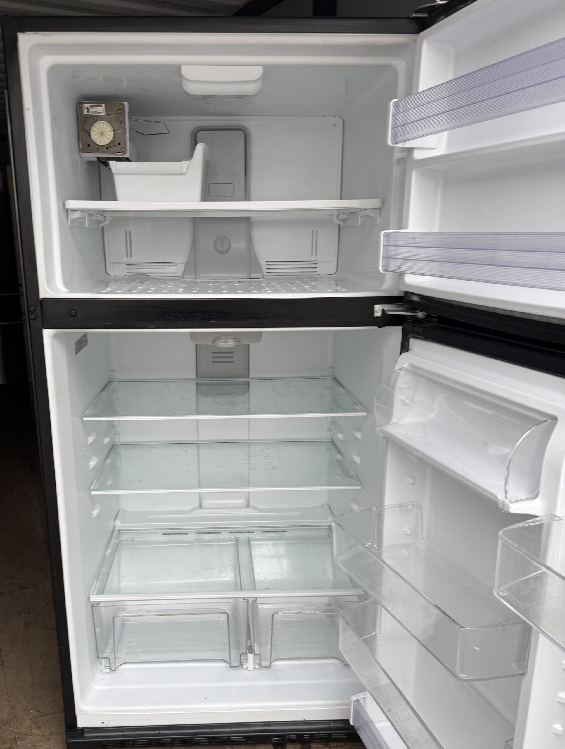 Whirlpool refrigerator interior with glass shelves and crisper drawers