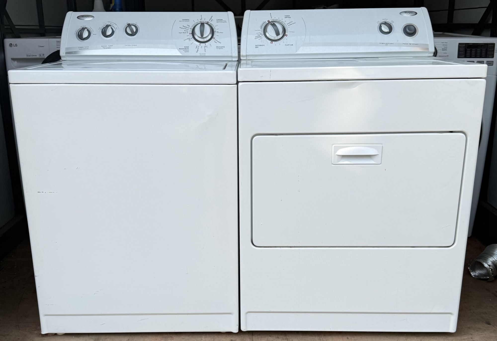 Whirlpool white top-load washer and electric dryer set, front view