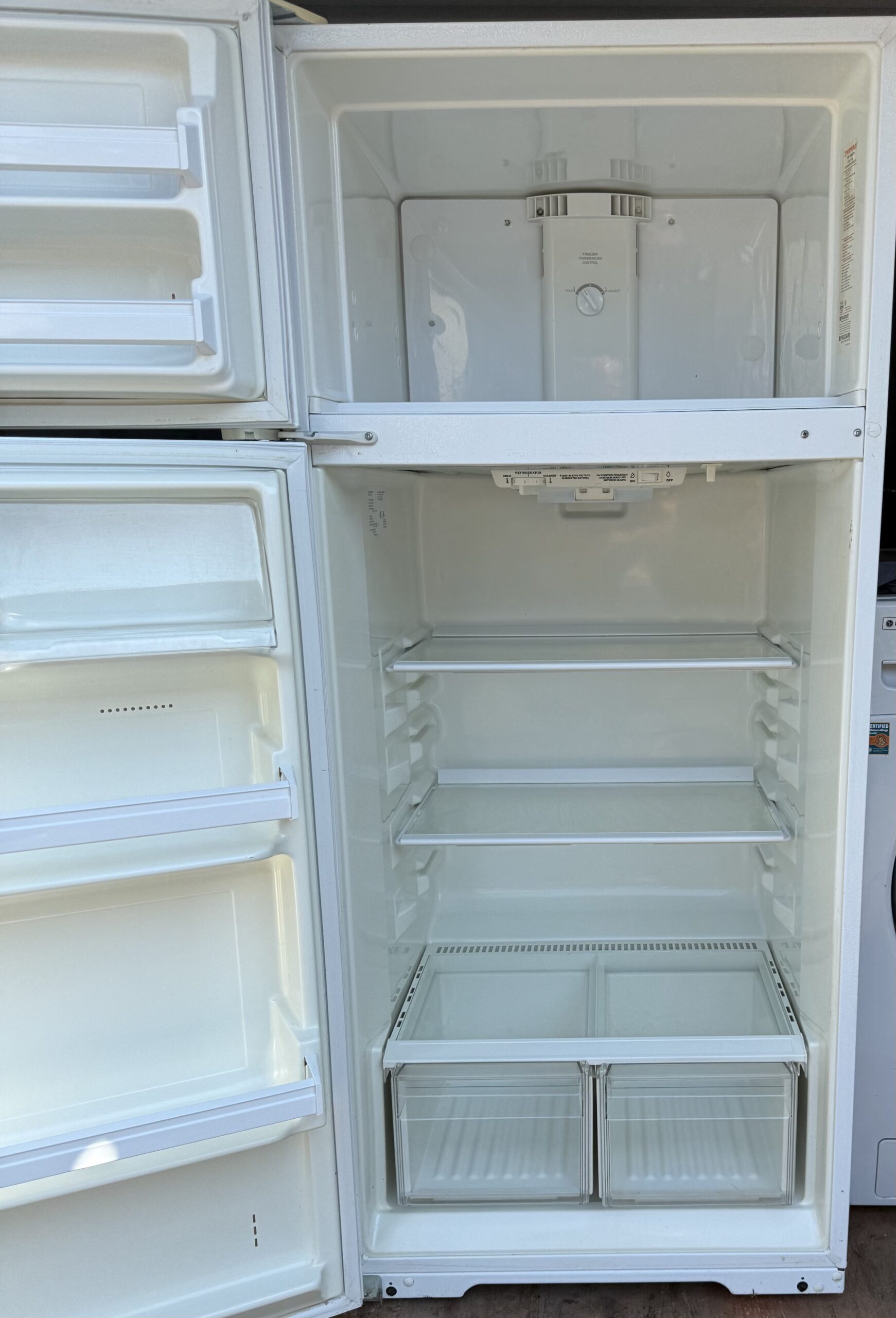 Tappan refrigerator interior with glass shelves and two crisper drawers, both doors open