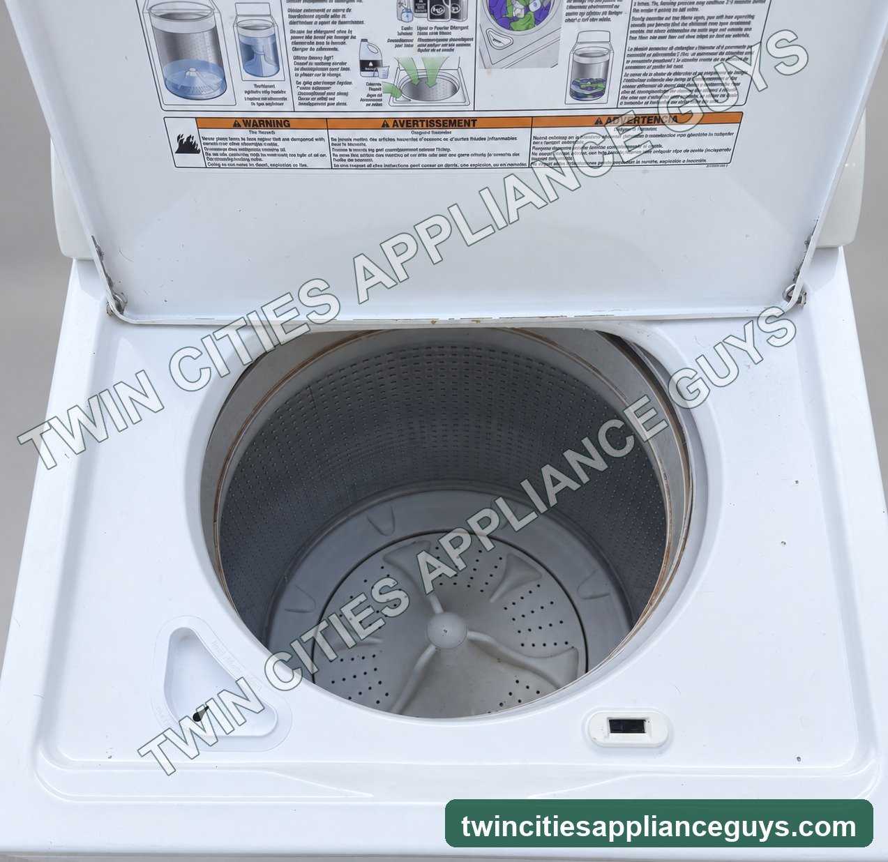 Whirlpool top-load washer with lid open showing the wash basket