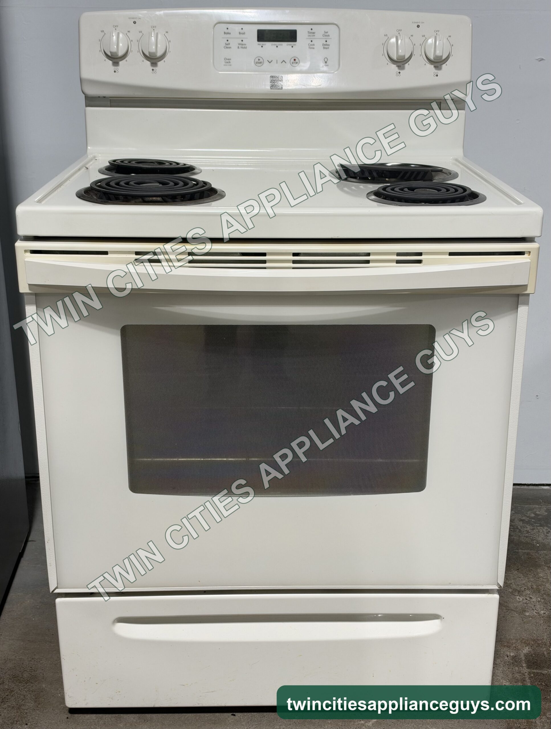 Bisque Kenmore electric range front view with four coil elements and the oven door closed