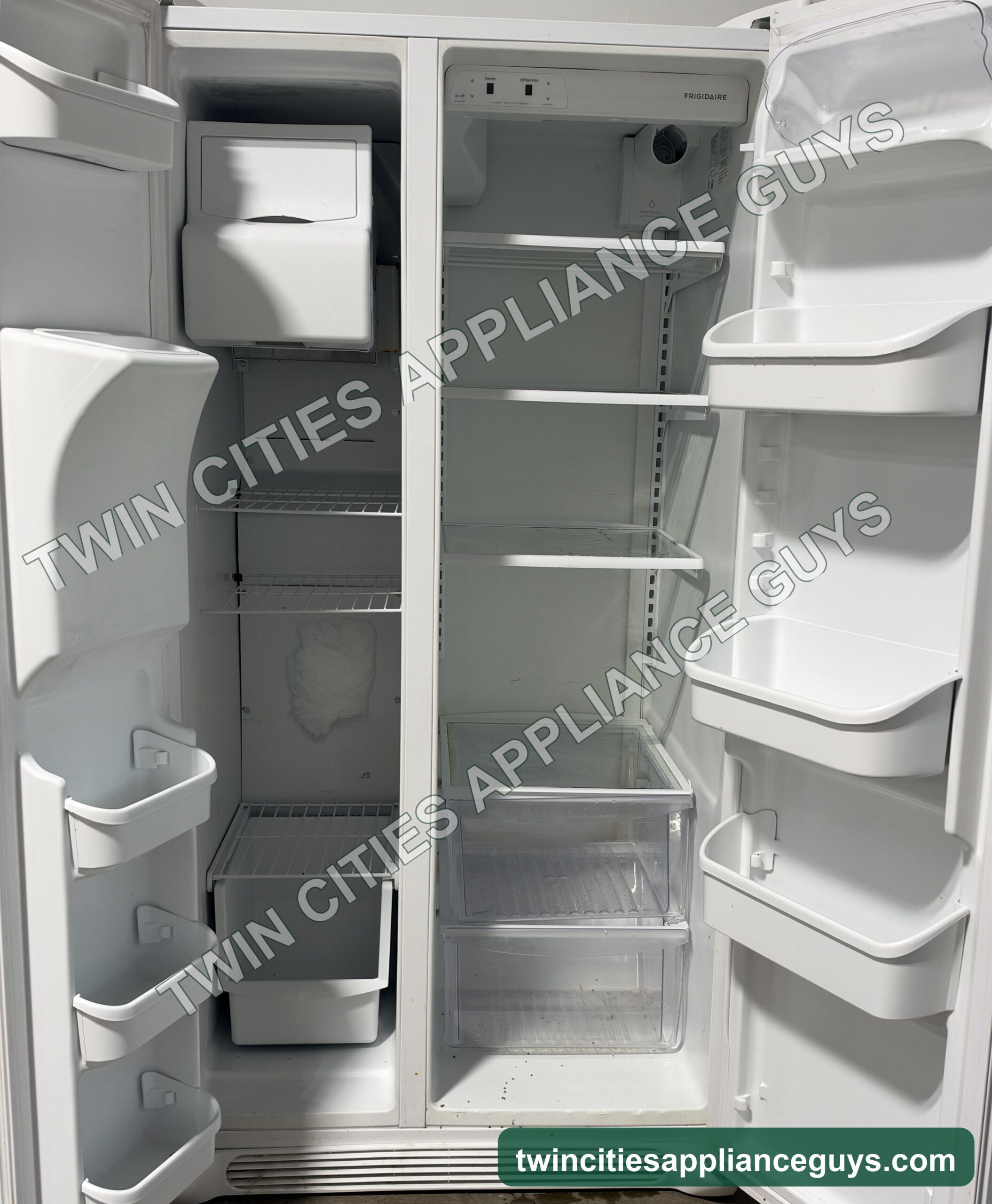Frigidaire side-by-side refrigerator with both doors open showing shelves, ice maker and door bins