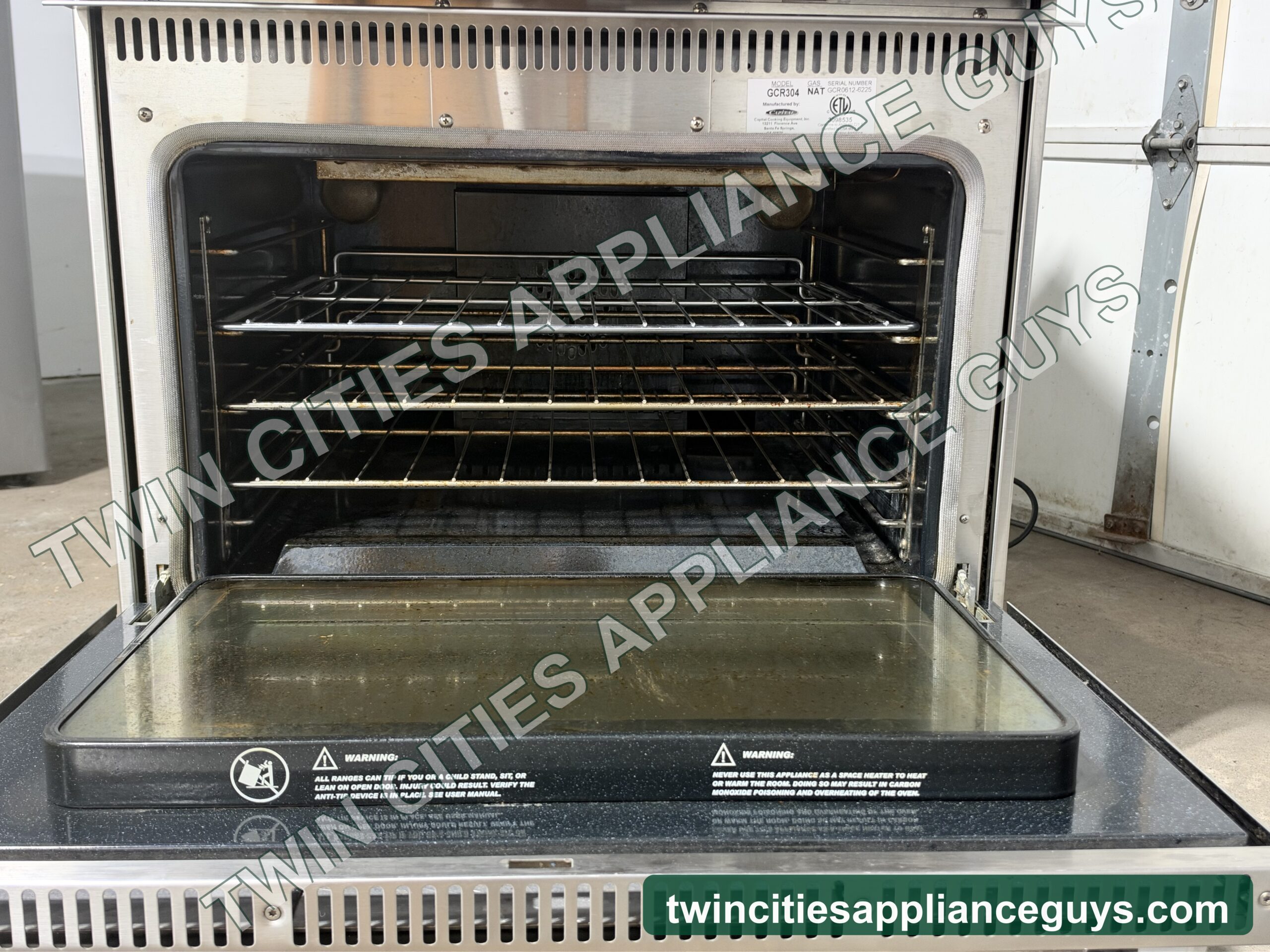 Capital gas range with the oven door open showing three oven racks