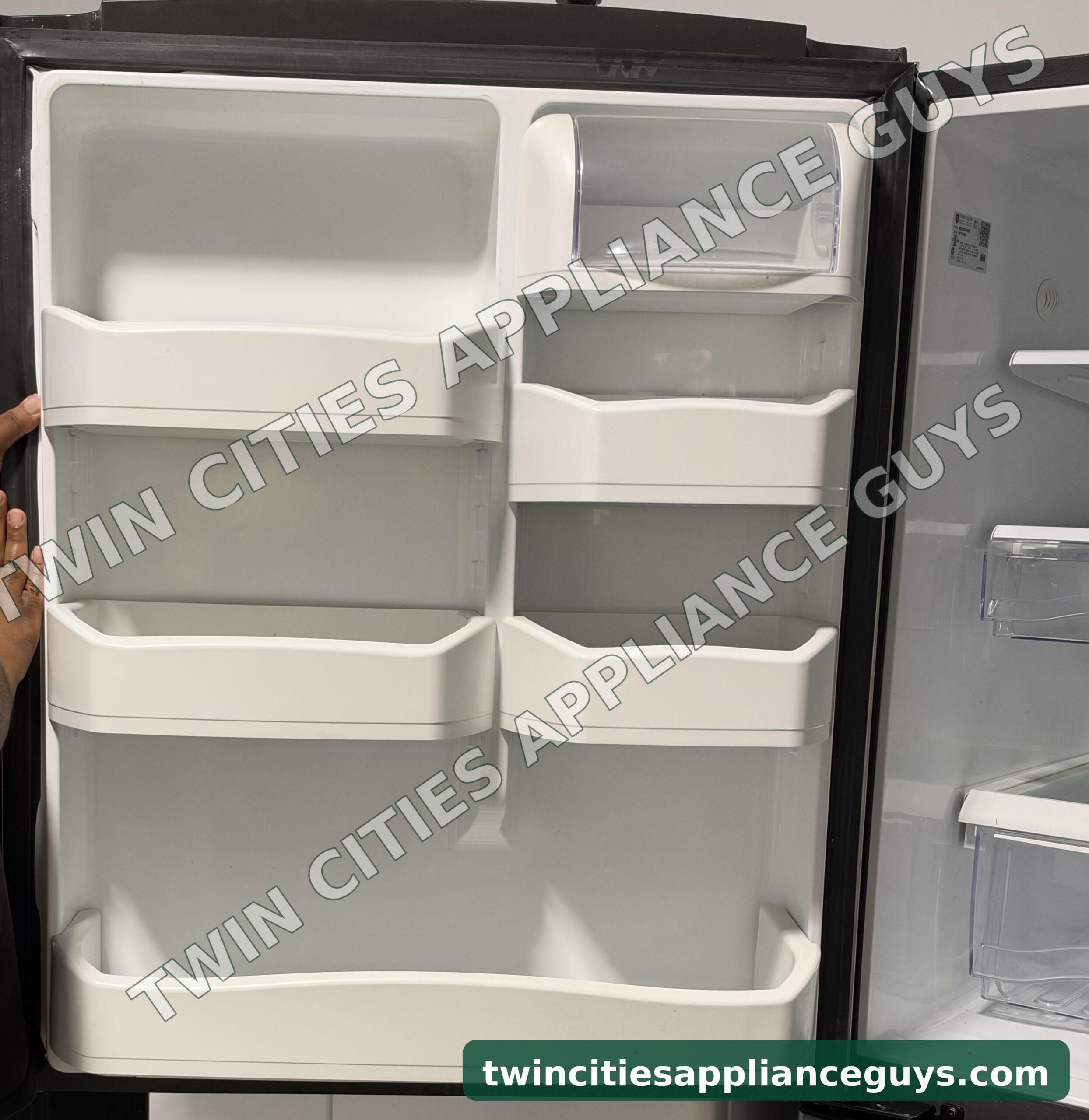 GE bottom-freezer refrigerator door interior showing the door bins