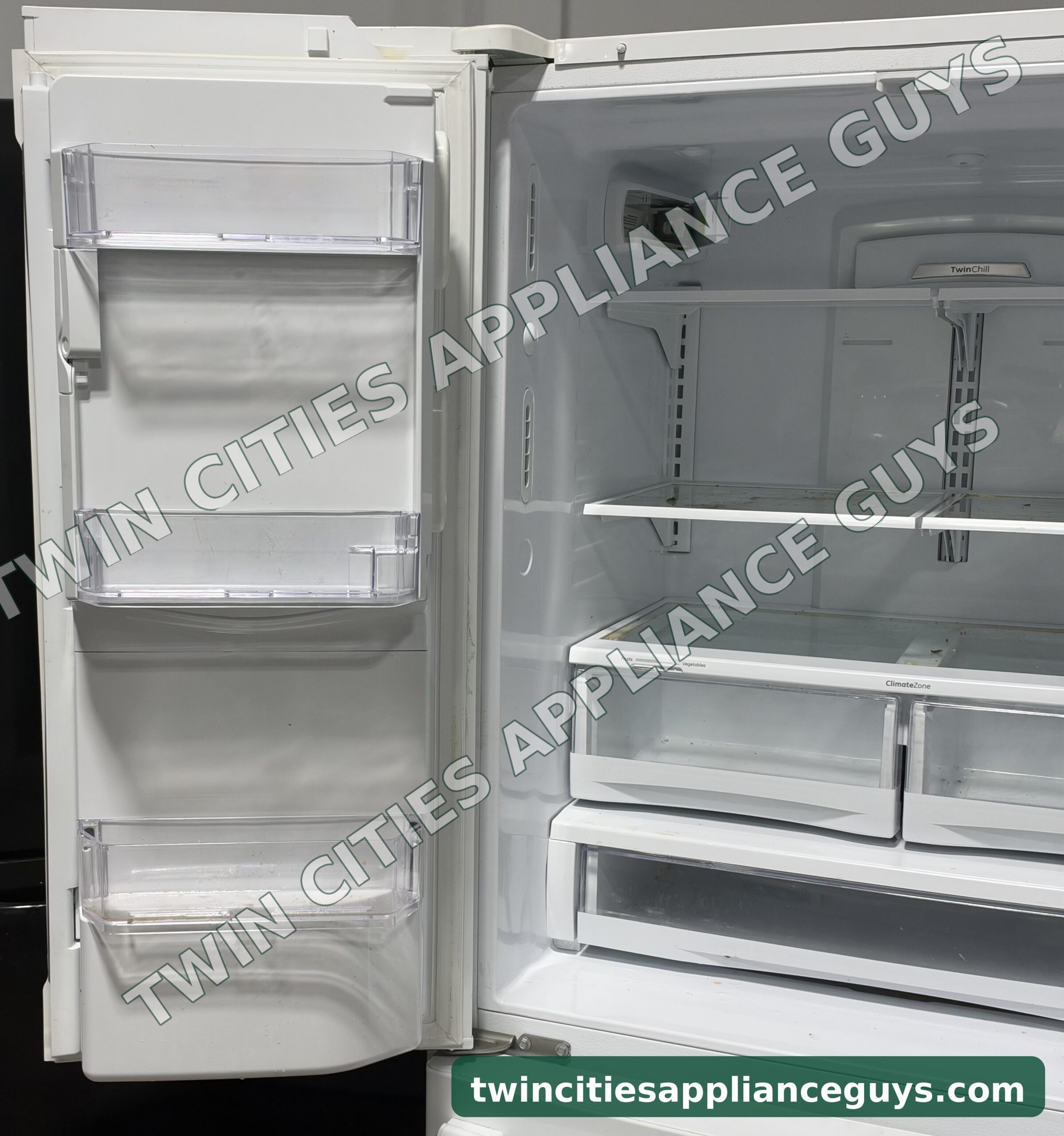 GE refrigerator left door open showing door bins beside the fresh food shelves