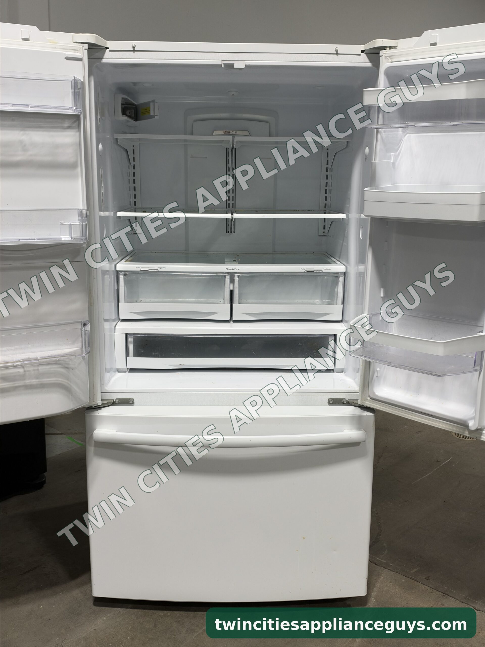 GE French door refrigerator with both doors open wide showing shelves, crispers and door bins