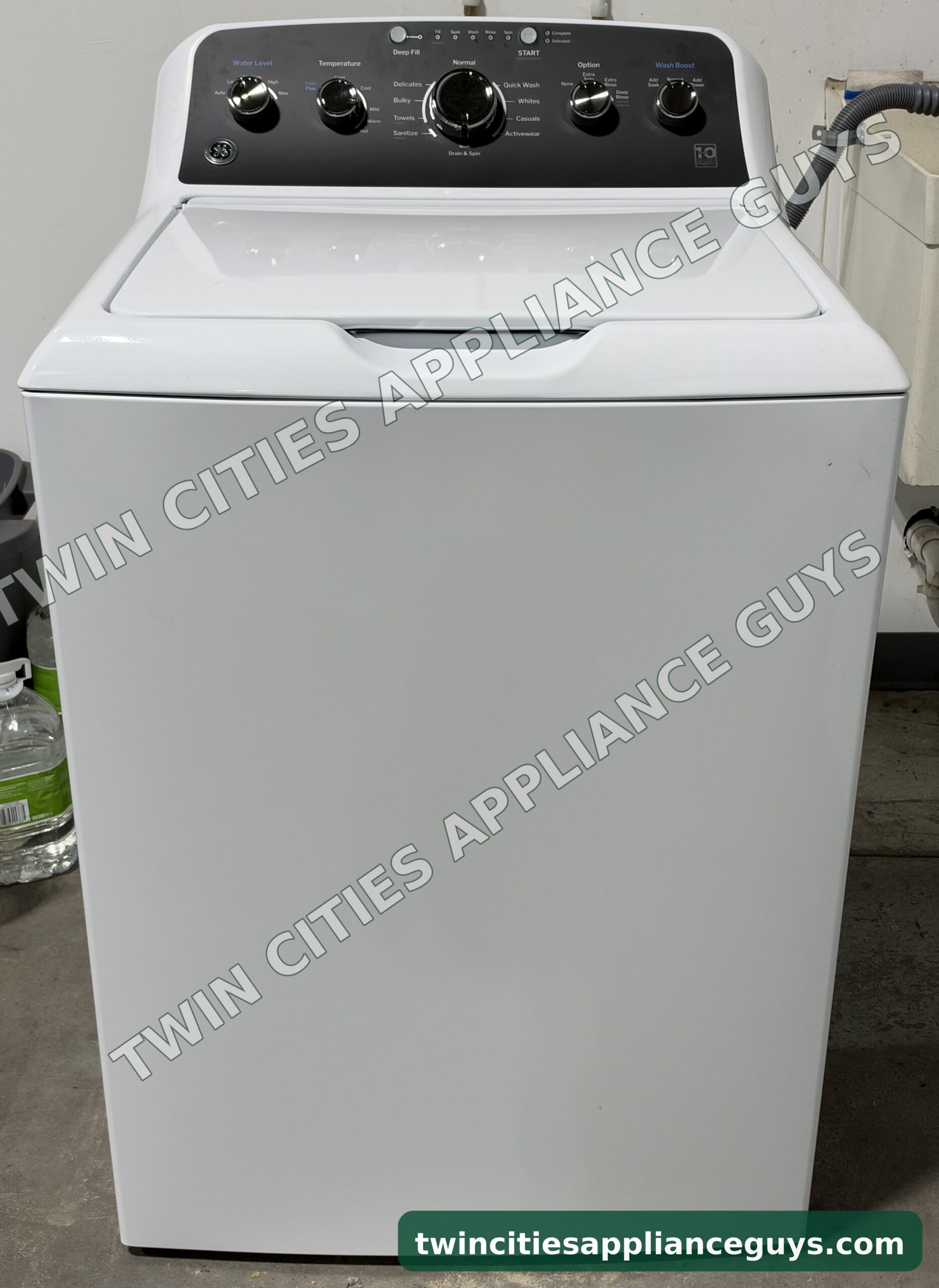 White GE top-load washer, front view with the lid closed and control panel