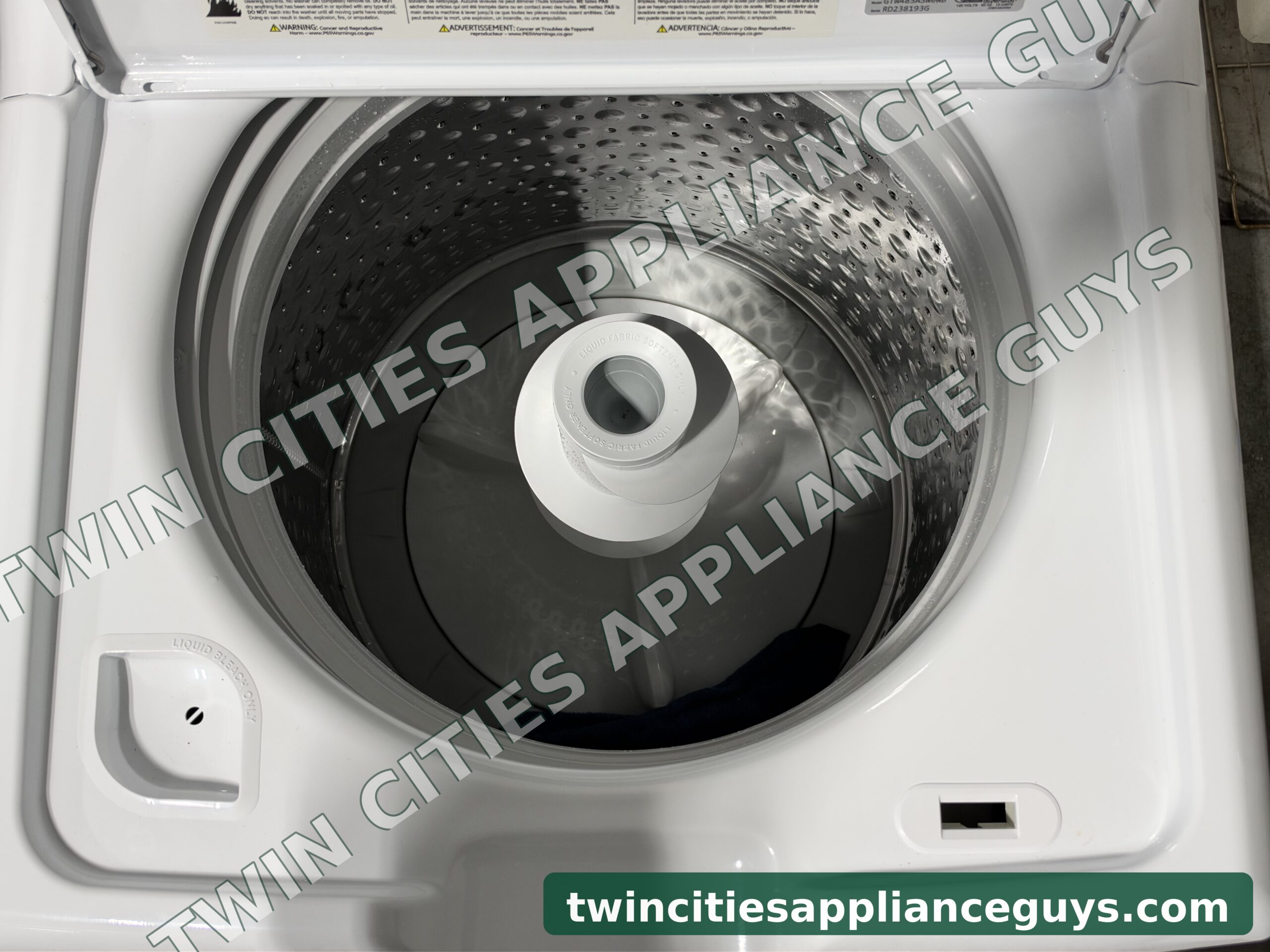 GE top-load washer with the lid open showing the wash basket from above