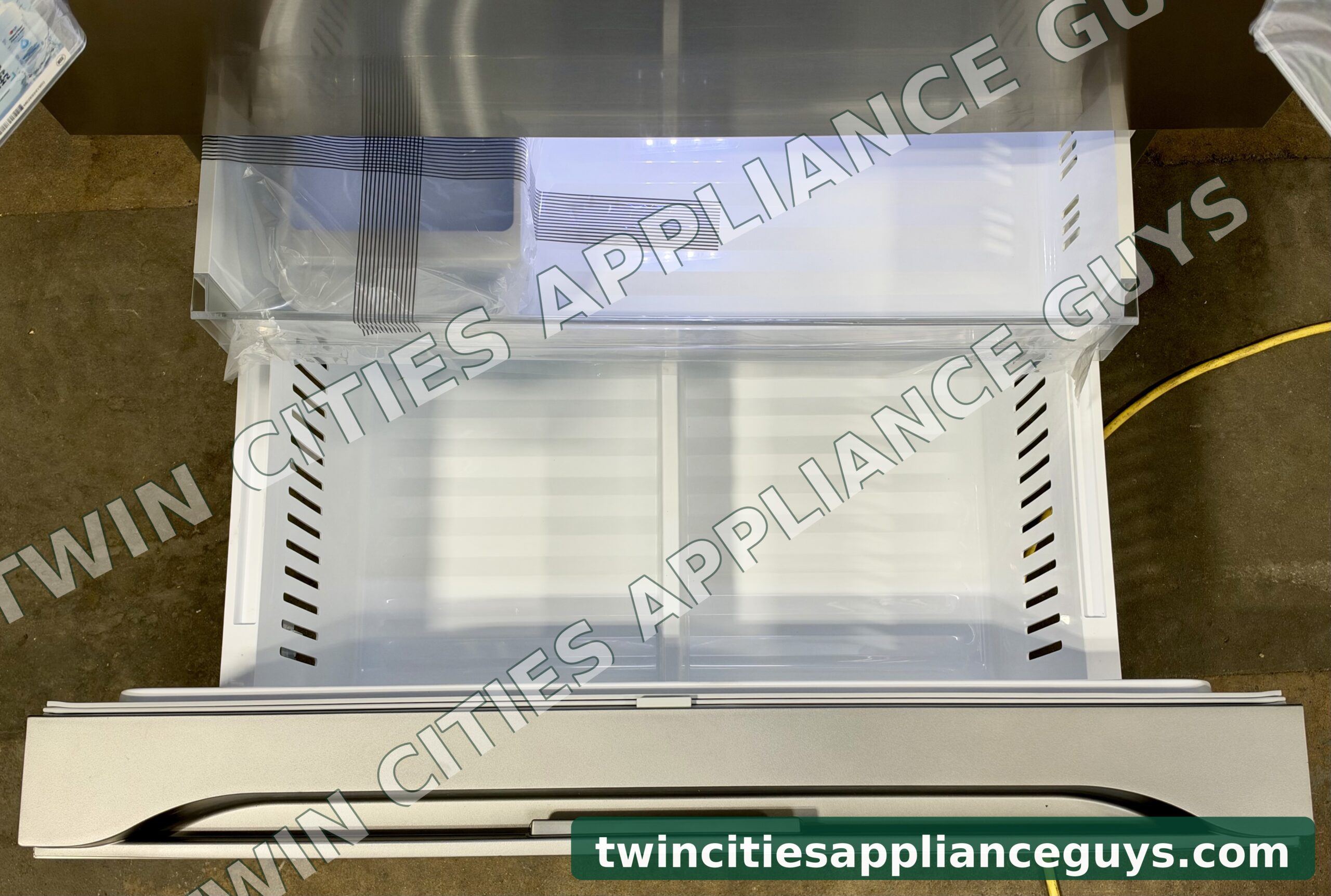 LG refrigerator bottom freezer drawer pulled open showing the freezer bins
