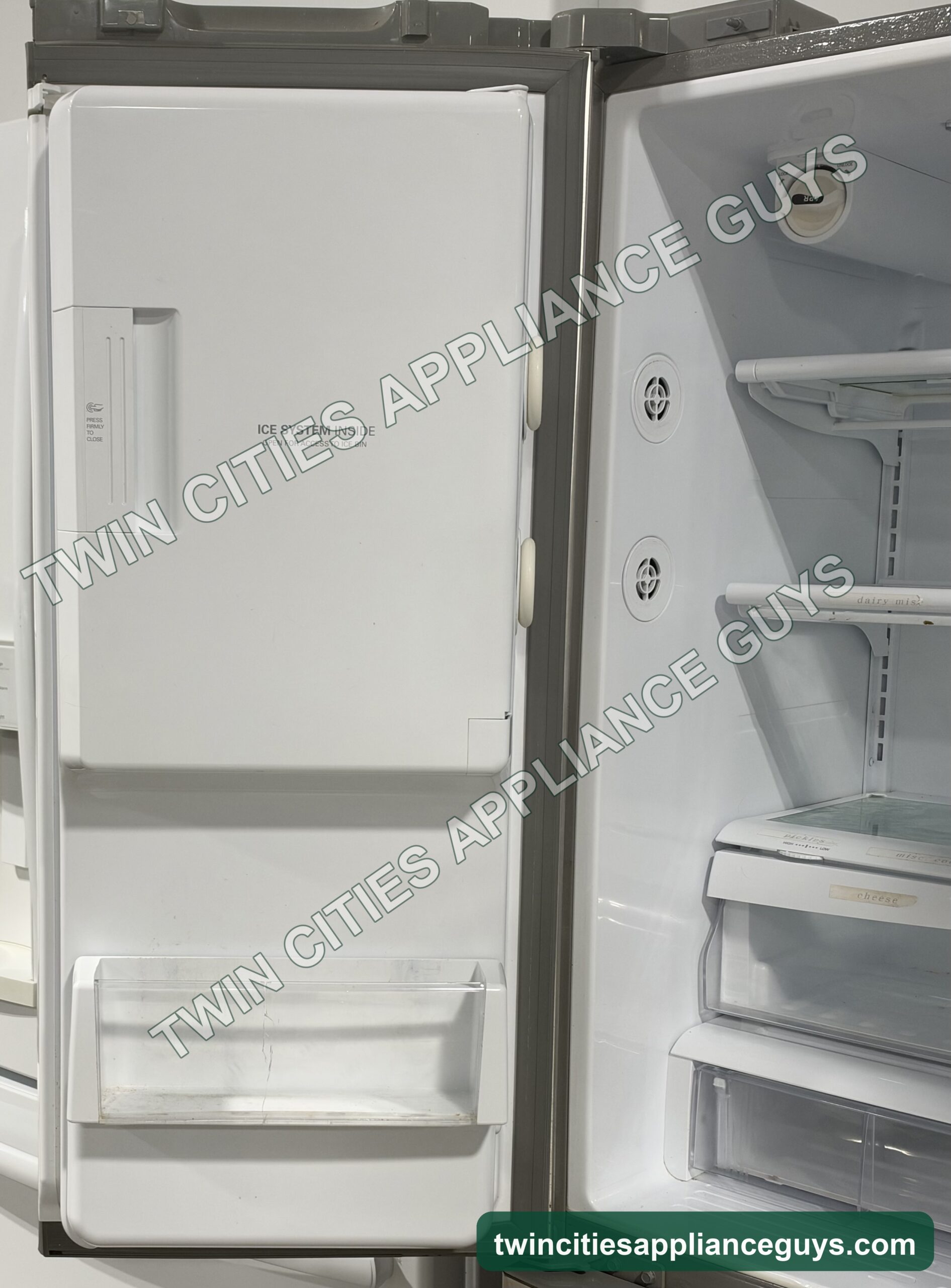 LG refrigerator with the left door open showing the in-door ice compartment beside the shelves