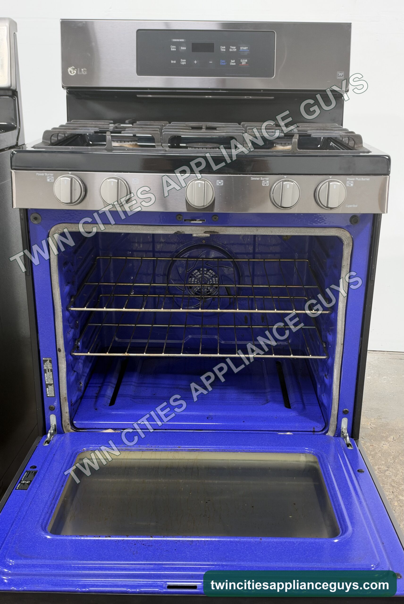 LG gas range with the oven door open showing the blue oven interior and racks