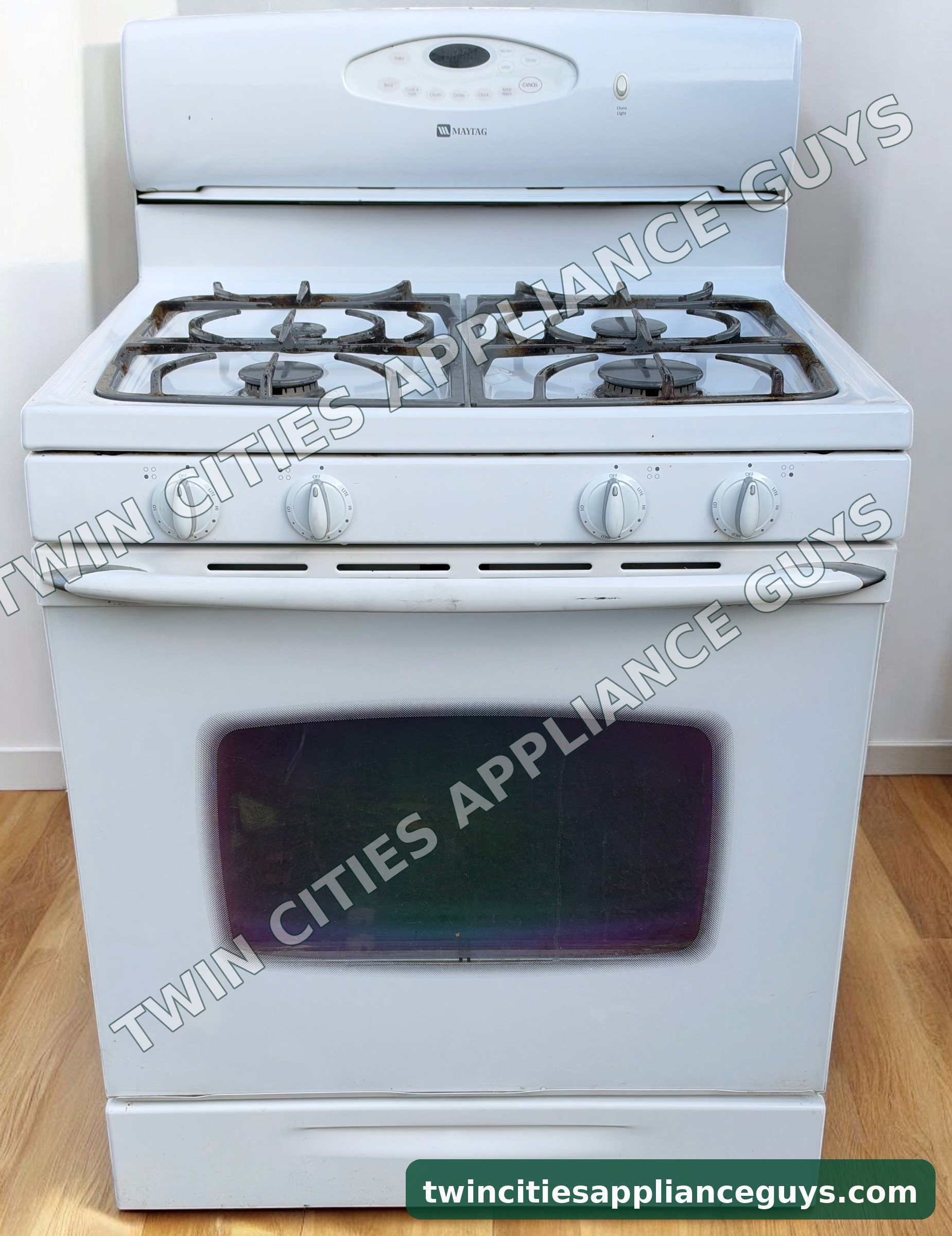 White Maytag gas range front view with four burner grates and oven door closed
