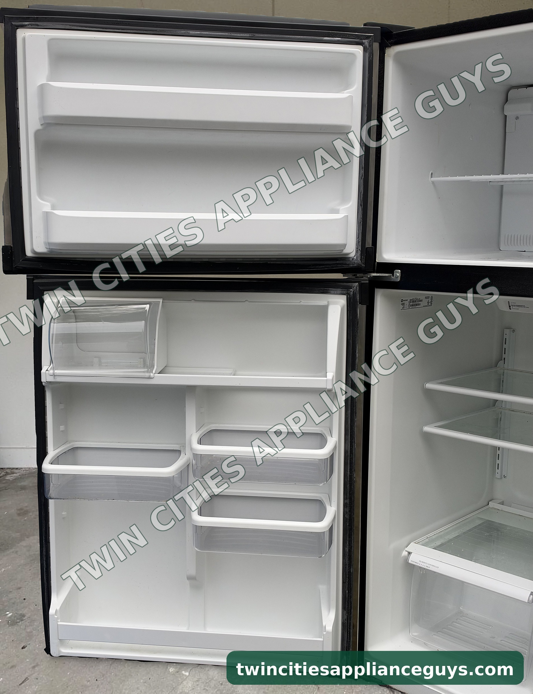 Maytag top-freezer refrigerator open showing door bins, dairy compartment and crisper drawers