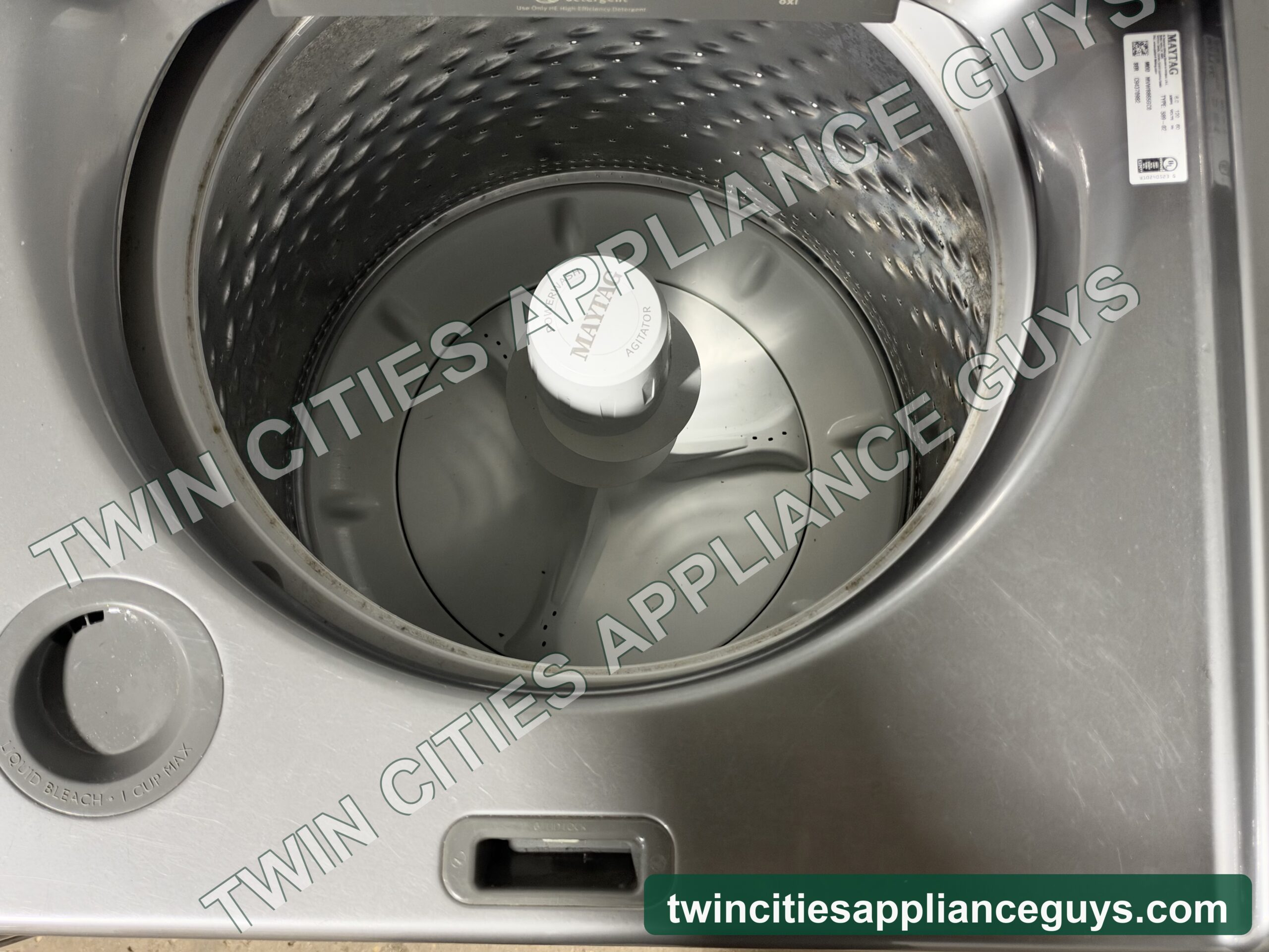 Maytag top-load washer with the lid open showing the wash basket and agitator