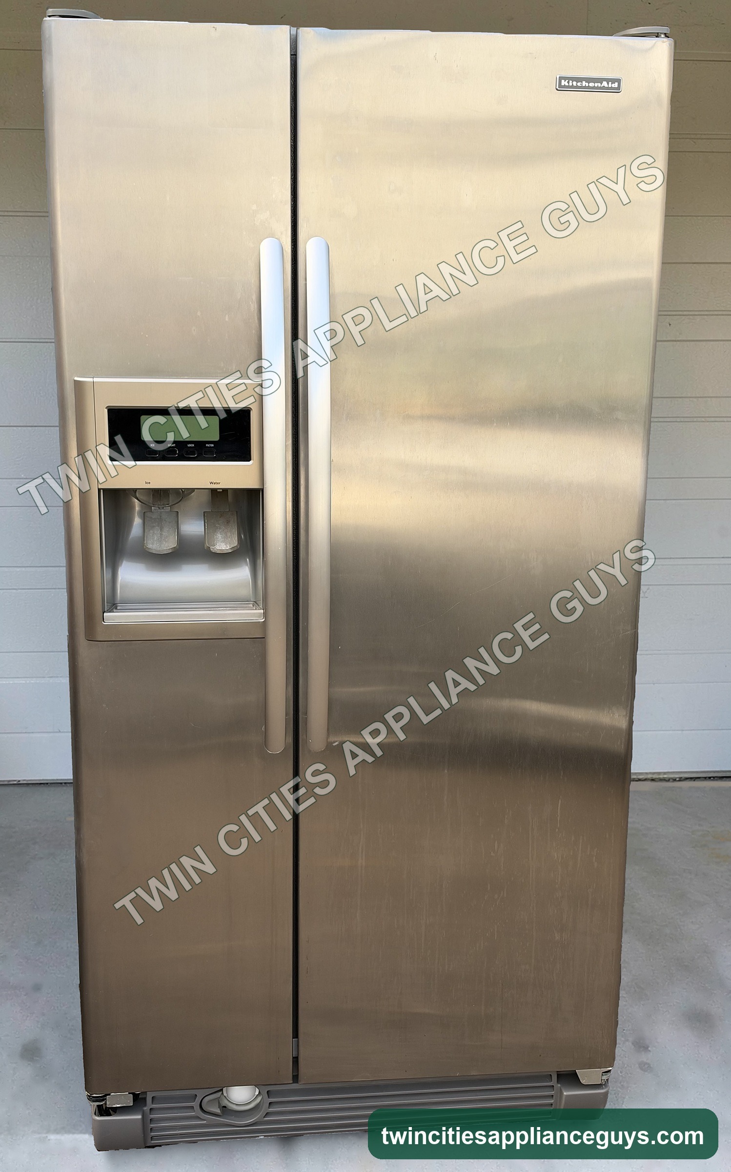 KitchenAid stainless side-by-side refrigerator front view with doors closed and door dispenser