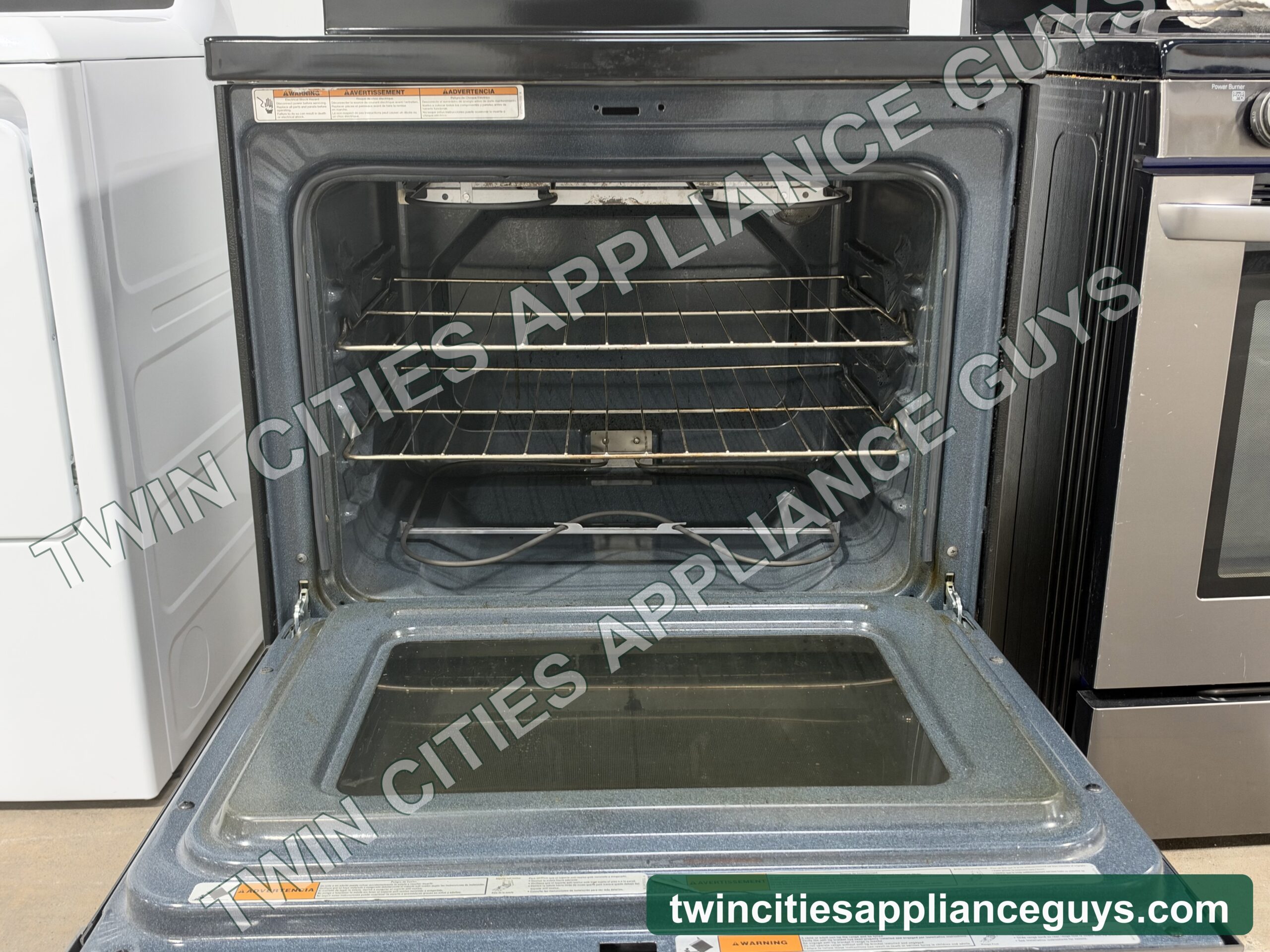 Whirlpool electric range with the oven door open showing the oven racks