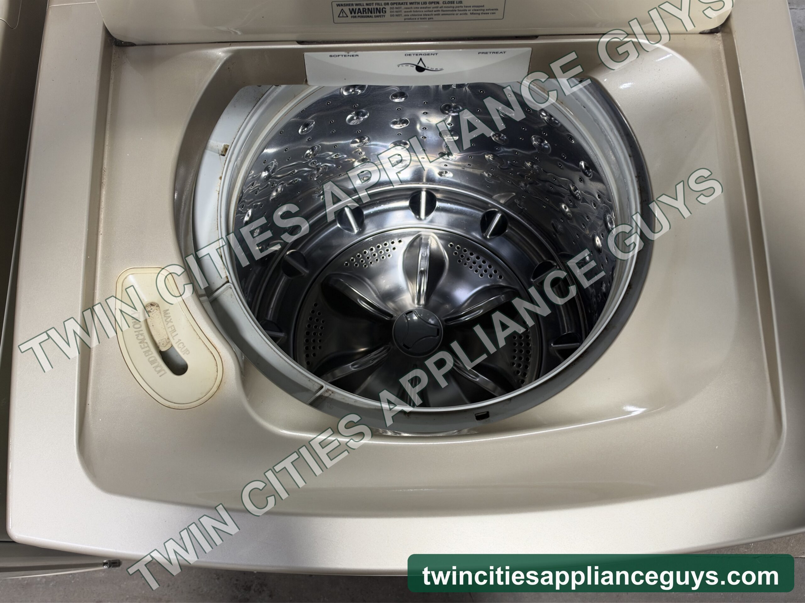 GE Profile top-load washer with the lid open showing the wash basket