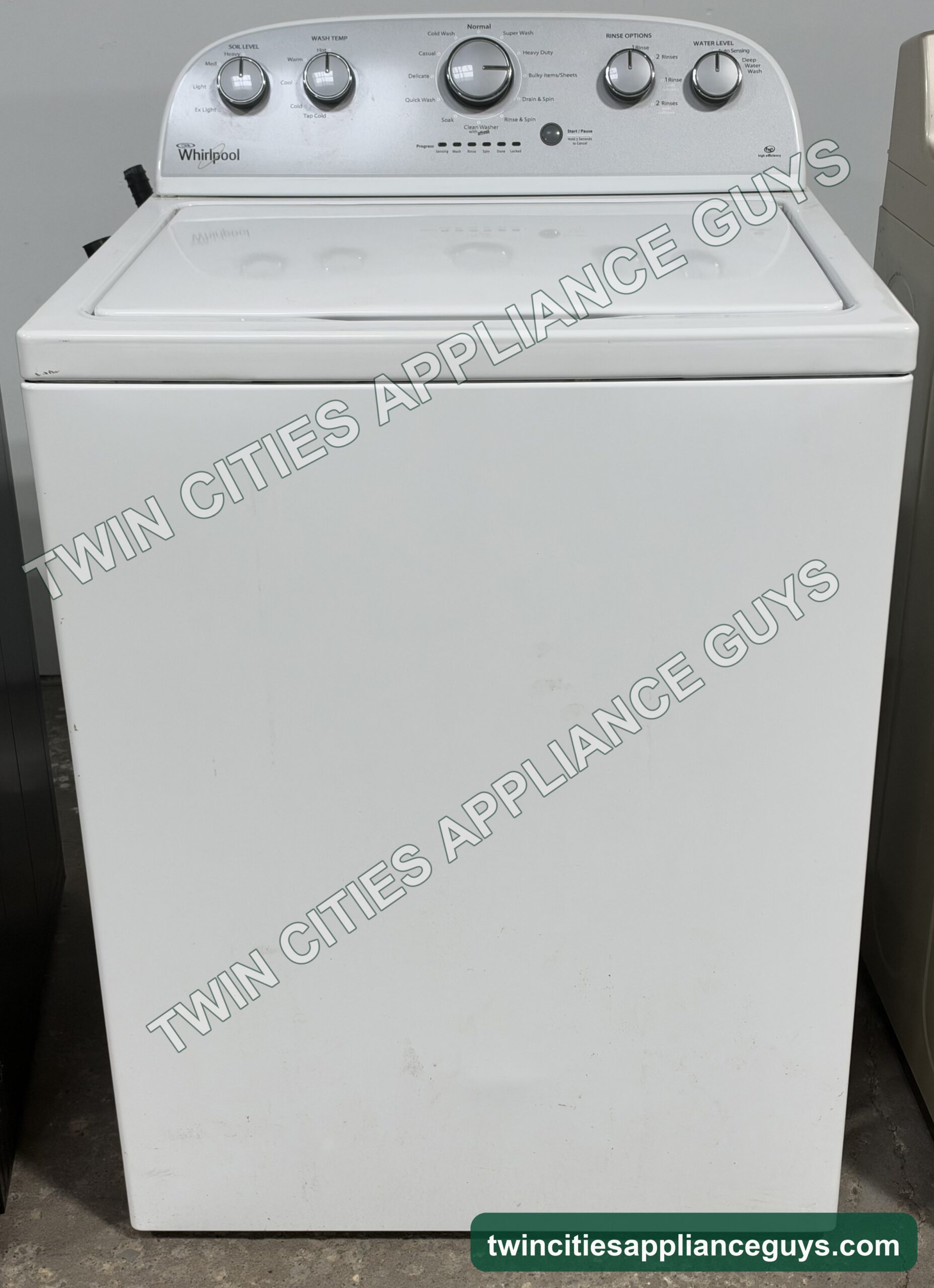 White Whirlpool top-load washer front view with the lid closed