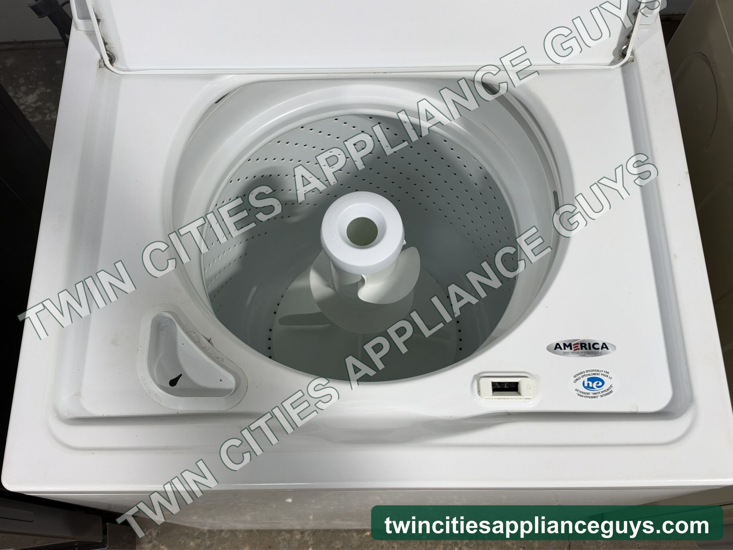 Whirlpool top-load washer with the lid open showing the wash basket and agitator